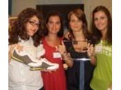 Quattro ragazze scarpe ricaricano cellulare